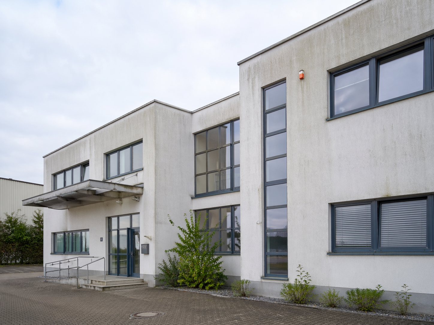 Gewerbeobjekt — Fassade mit Algen- und Wetterstreifen — vorher